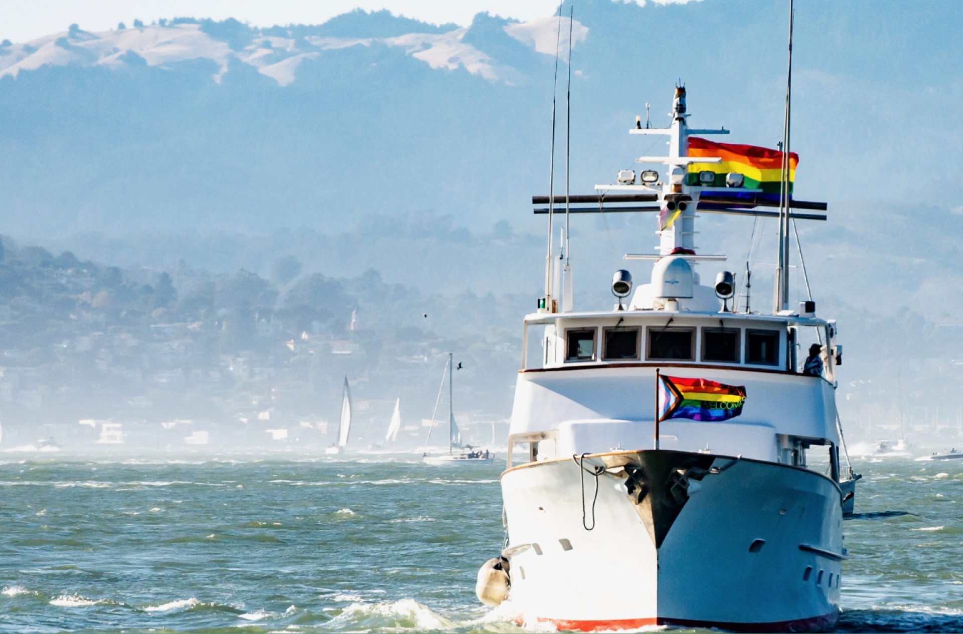 Yacht cruising with rainbow flag flying